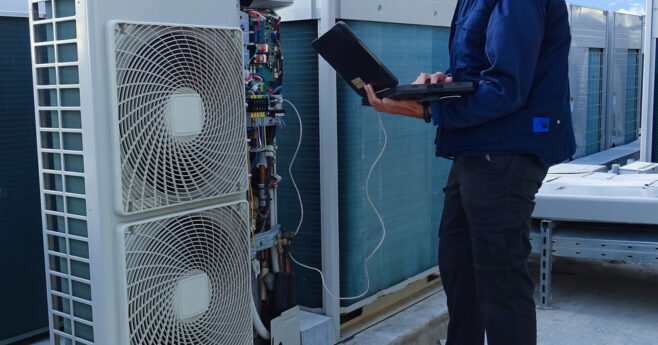 Air conditioning technician examining VRV outdoor unit