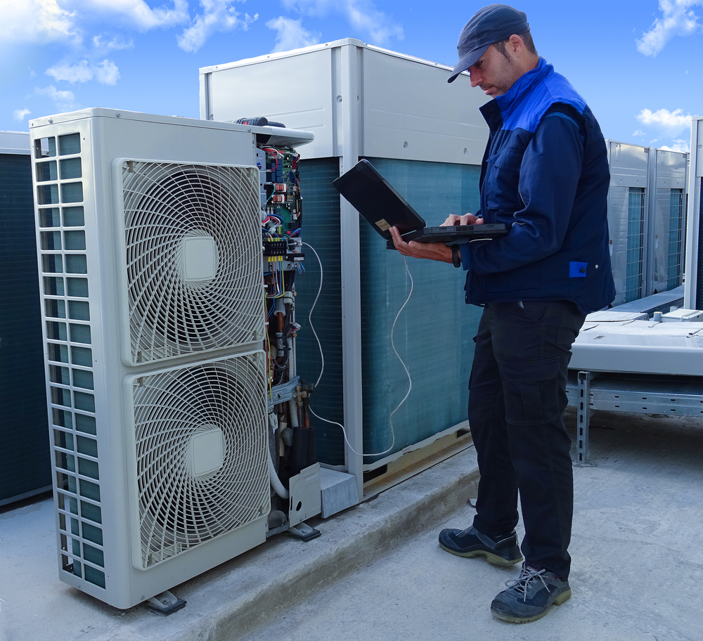 Air conditioning technician examining VRV outdoor unit