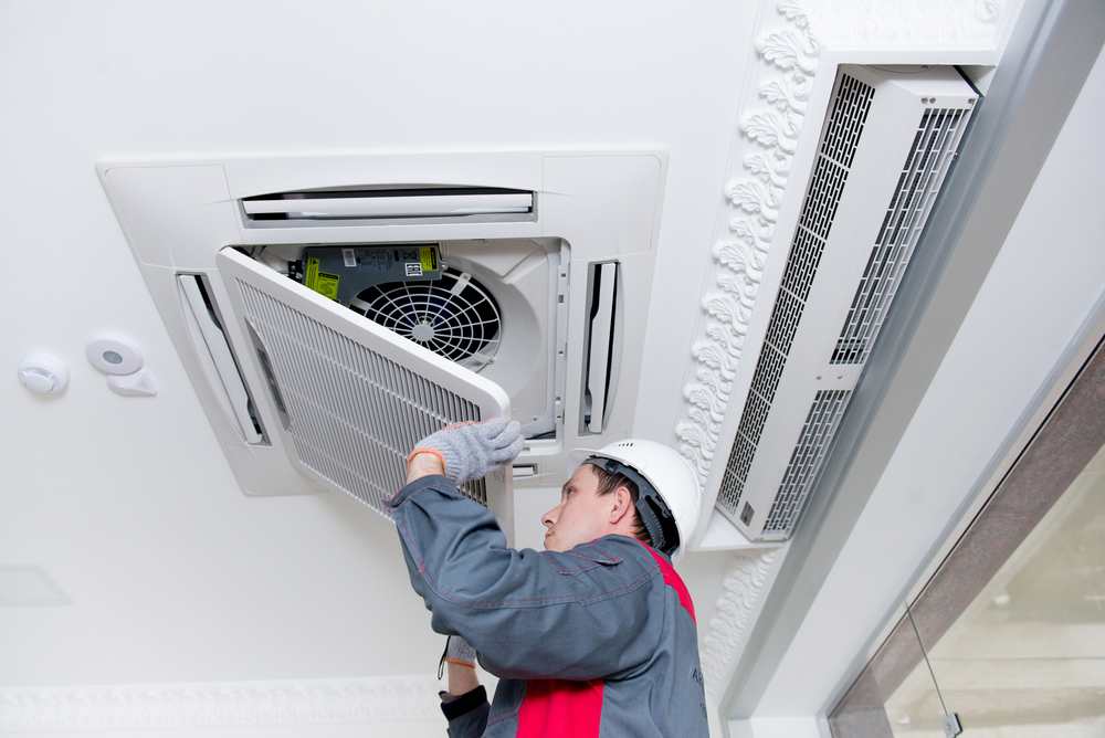 Technician working on cassette air conditioning system