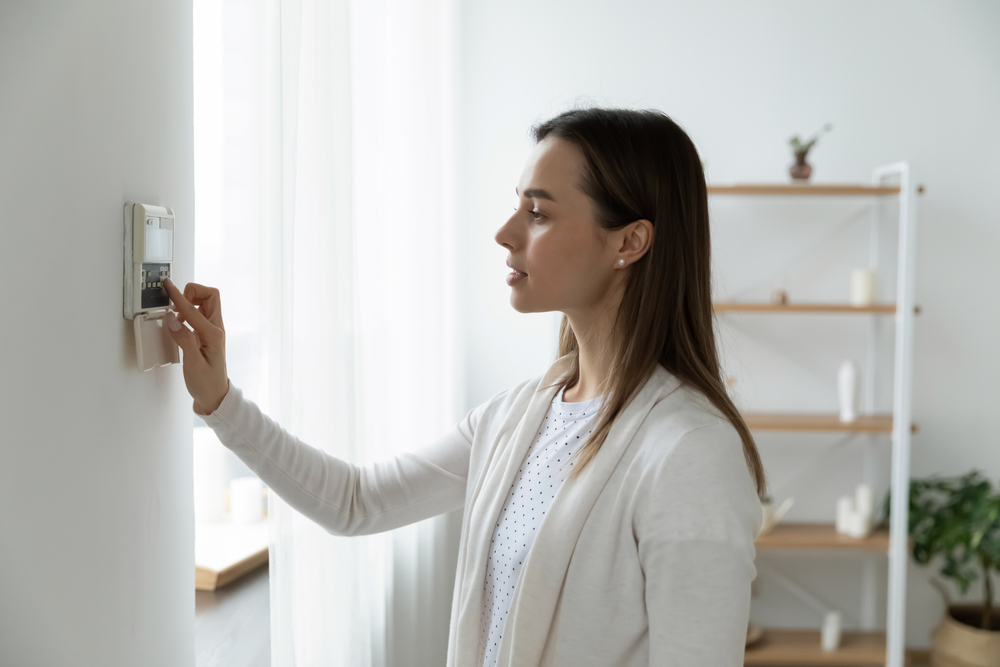 Girl setting Thermostat to the Right Temperature